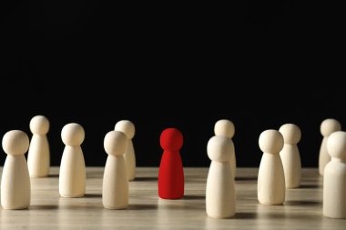 Farklılık, eşsizlik, bireysellik. Kırmızı insan figürü, siyah arka planda tahta olanlar arasında.