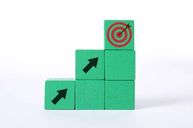 Hedef alınıyor. Yığılmış küplerin üzerinde beyaz arka planda hedef tahtası olan oklar var.