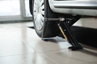 Servis istasyonunda makas kriko ile kaldırılan araba, metin için boşluk