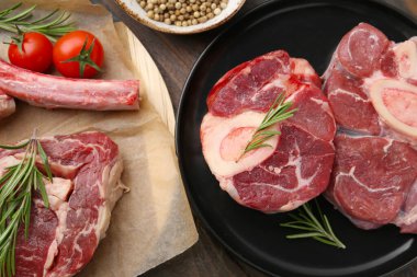 Tahta masada çiğ et, biberiye ve domates parçaları.