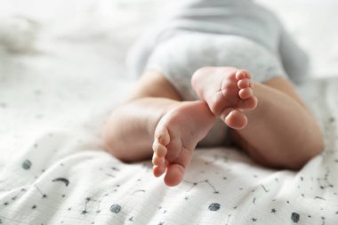 Küçük bebek yatakta uzanıyor, yakın plan.