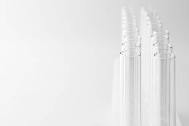 Işık arkaplanındaki boş test tüpleri, metin için boşluğa yakın çekim. Laboratuvar camları.