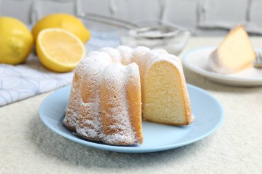 Açık dokulu masaya pudra şekerli lezzetli limonlu pasta, yakın plan.