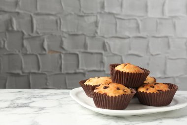 Beyaz mermer masa üzerinde çikolata parçalı lezzetli kek, metin için yer var.