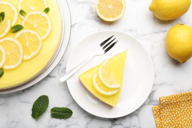 Lezzetli limonlu cheesecake, nane, narenciye meyvesi ve çatal beyaz mermer masa, düz yatıyordu.