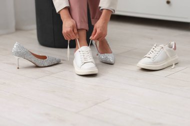 Evde ayakkabı değiştiren kadın, yakın çekim manzarası.