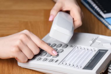 Ahşap masada telefonla arayan kadın, yakın plan.