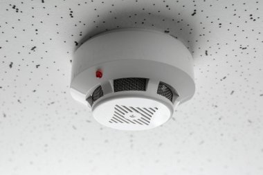 Işık desenli arka planda duman dedektörü, yakın plan. Alarm sistemi