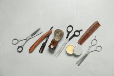 Many different barber's tools on light grey background, flat lay