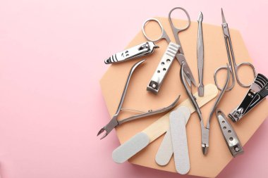 Pembe arka planda farklı manikür aletleri var. Metin için boşluk