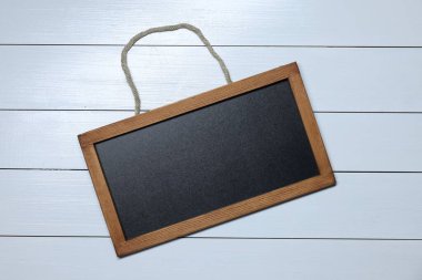 Beyaz ahşap zemin üzerinde boş küçük karatahta, üst görünüm
