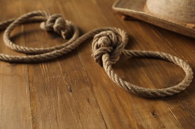 Pamuk ipten ve ahşap arka planda hasır şapkadan yapılmış kement, yakın plan.