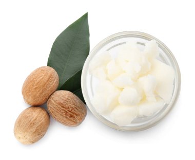 Doğal tereyağı kasede, fındık ve yeşil yapraklar beyaza izole edilmiş, üst manzara.