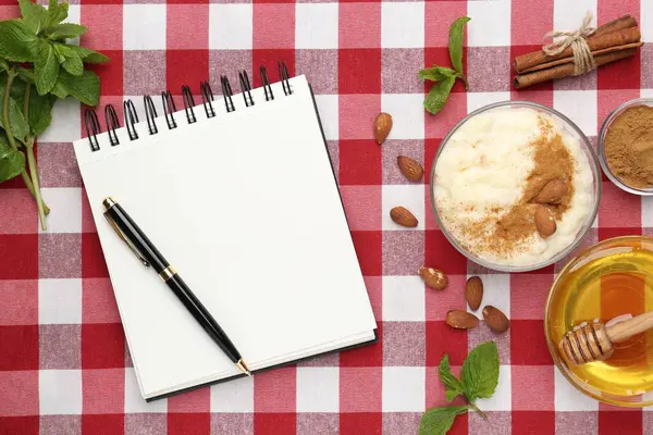 Boş tarif kitabı, tatlı ve malzemeler kırmızı kareli peçete üzerinde, düz uzanmış
