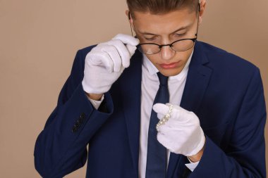 Bej arka plandaki lüks mücevherleri değerlendiren eksper