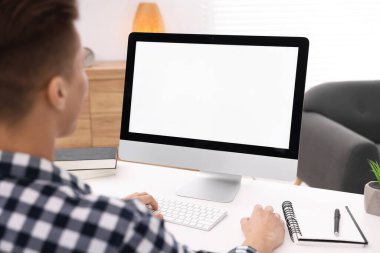 Ofisteki beyaz masada bilgisayarda çalışan bir adam, yakın plan. Tasarım için model