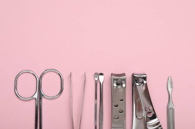Pembe arka planda farklı manikür aletleri var. Metin için boşluk