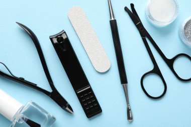Açık mavi zemin üzerinde farklı manikür araçları kümesi, düz yatıyordu