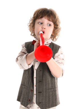 Beyaz arka planda oyuncak trompet çalan sevimli küçük çocuk.