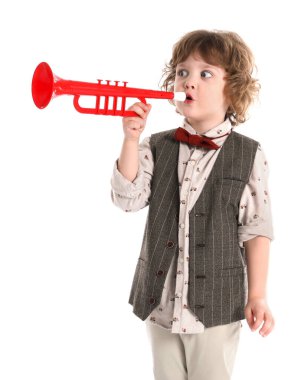 Beyaz arka planda oyuncak trompet çalan sevimli küçük çocuk.