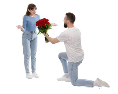 Adam beyaz arka planda sevgilisine kırmızı gül buketi sunuyor.