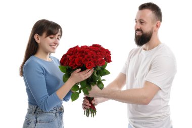 Adam beyaz arka planda sevgilisine kırmızı gül buketi sunuyor.