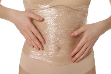 Kadın göbeğine sarılıp beyaz arka plana sarılıyor, yakın plan.