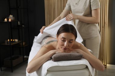 Spa vücut sargıları. Estetisyen kadın çarşaflı, kapalı