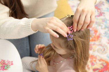 Annem evde kızının saçına sevimli aksesuarlar takıyor.