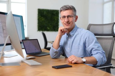 Ofisinde cihazları olan gülümseyen mühendisin portresi