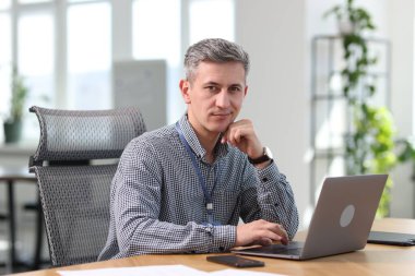 Ofiste dizüstü bilgisayarla çalışan mühendisin portresi