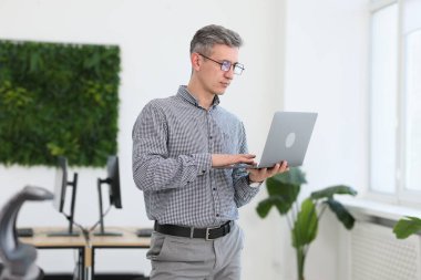 Ofiste dizüstü bilgisayarla çalışan profesyonel bir mühendis.