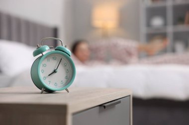 Evde yatakta egzersiz yapan genç bir kadın. Çalar saate odaklan. Sabah rutini