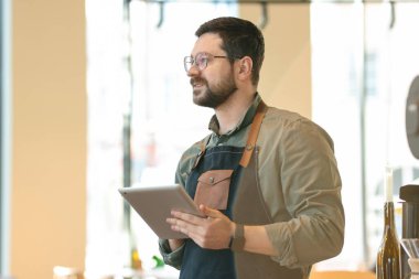 Kafesinde tableti olan yakışıklı bir iş adamı.