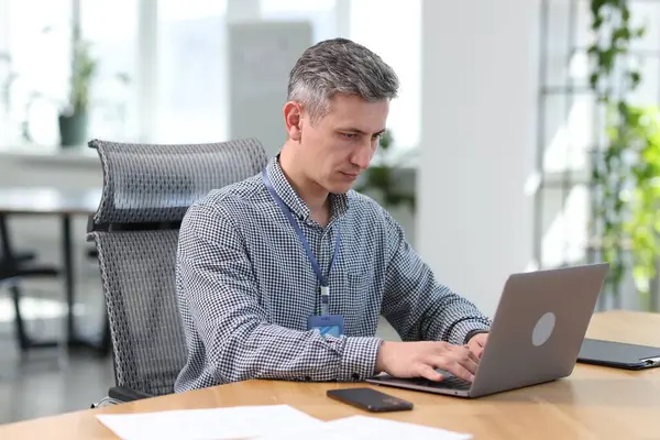 Ofisteki masada dizüstü bilgisayarla çalışan mühendis.