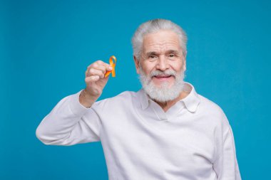 Çoklu Skleroz farkındalığı. Açık mavi arka planda turuncu kurdeleli son sınıf öğrencisi.