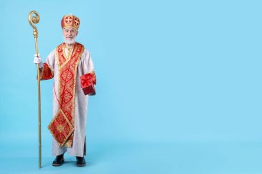 Açık mavi arka planda hediyeli Aziz Nicholas. Metin için boşluk