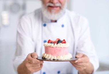 Bulanık arka planda lezzetli pastalı pasta şefi, yakın plan.