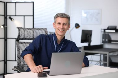 Ofisinde cihazları olan gülümseyen mühendisin portresi