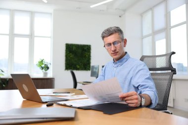 Ofiste evrak işleriyle uğraşan bir iş adamı.