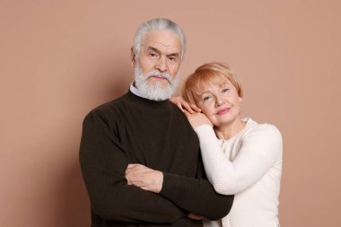 Bej arka planda sevimli yaşlı bir çiftin portresi