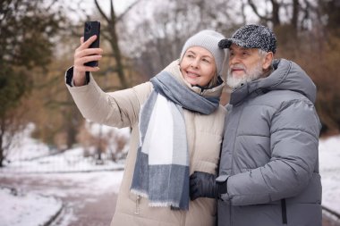Kış parkında selfie çeken mutlu çift.