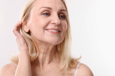 Beyaz arka planda gülümseyen orta yaşlı kadın. Metin için boşluk