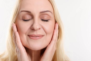 Beyaz arka planda orta yaşlı güzel bir kadının portresi. Metin için boşluk