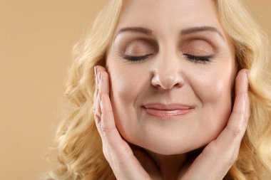 Güzel orta yaşlı kadın bej arka planda