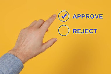 Adam turuncu arkaplan ile sanal ekranda Onaylamayı seçiyor, yakın plan