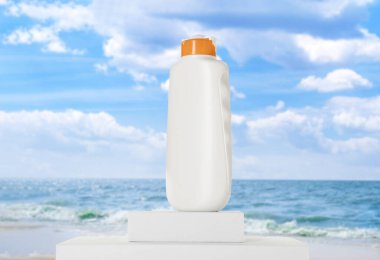 Deniz kenarında bir şişe güneş kremi. Podyumlu şık bir sunum