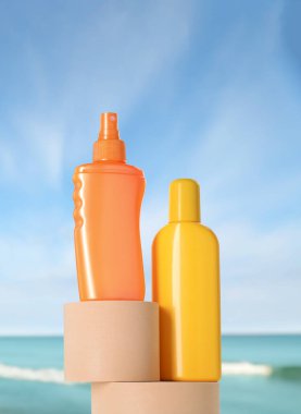 Okyanus kıyısındaki sahilde güneş kremi ürünleri. Podyumlu şık bir sunum