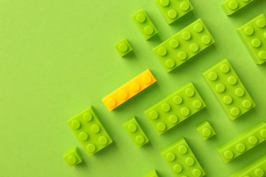 Farklılık, eşsizlik, bireysellik. Renk arkaplanı, üst görünümü yeşil olanlar arasında sarı yapı bloğu