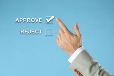 Açık mavi arkaplan karşısında sanal ekranda Onaylamayı seçen adam, yakın plan